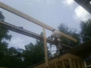 Carpenter setting a ridge beam over a new addition frame — Ice Dam Removal by Roofing Brothers in Walkersville