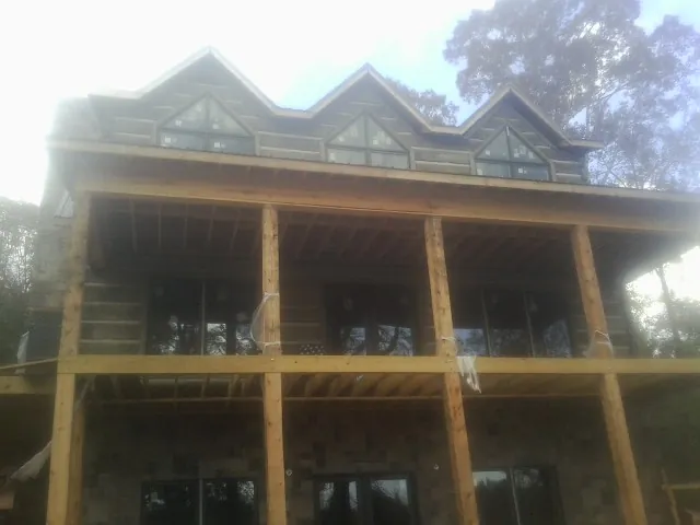 Dormers and porch framing on a large log home under construction — Roof Coating work by our crew in Walkersville