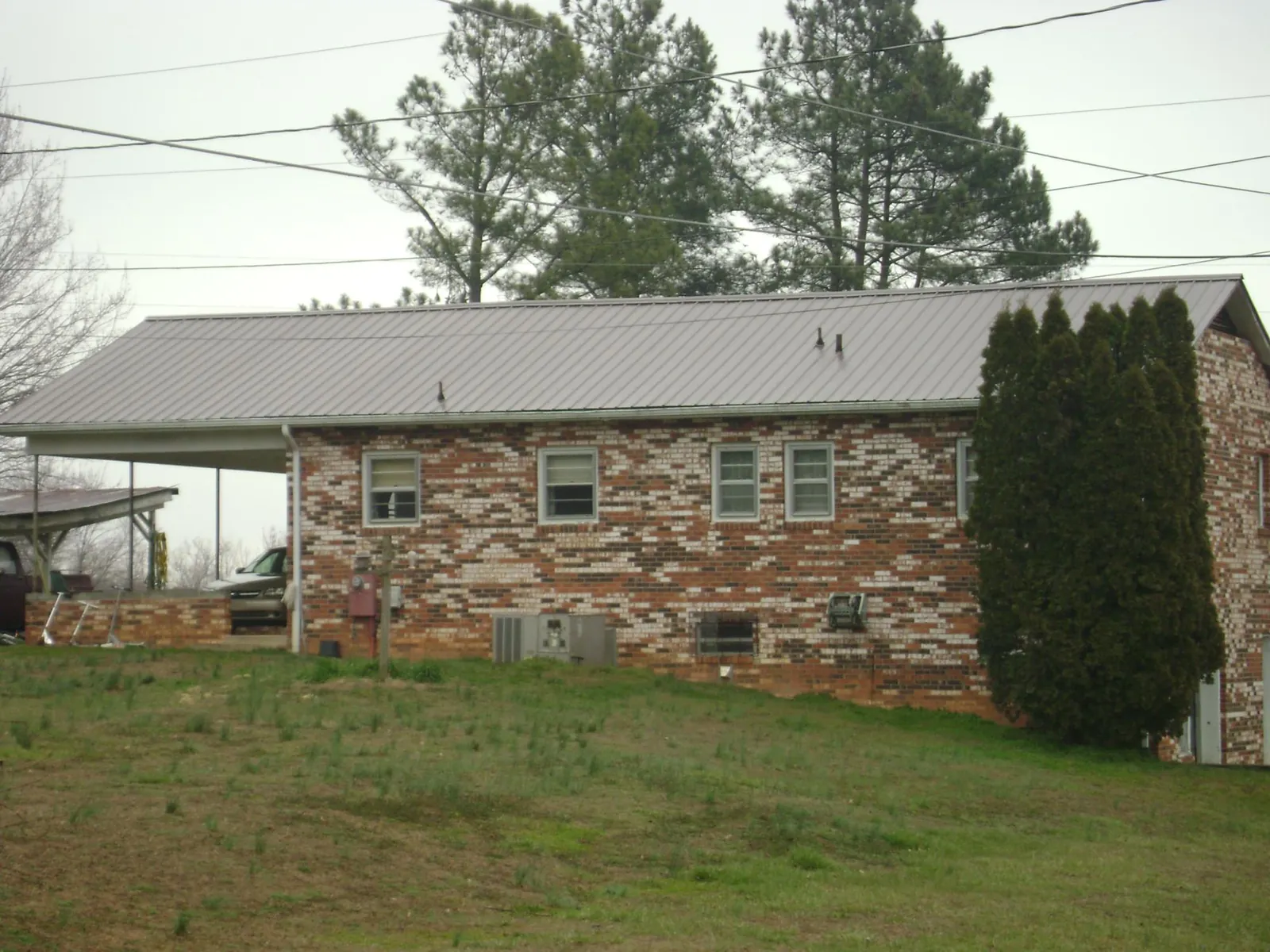 Gray metal roof on a brick split level home with a carport in Walkersville