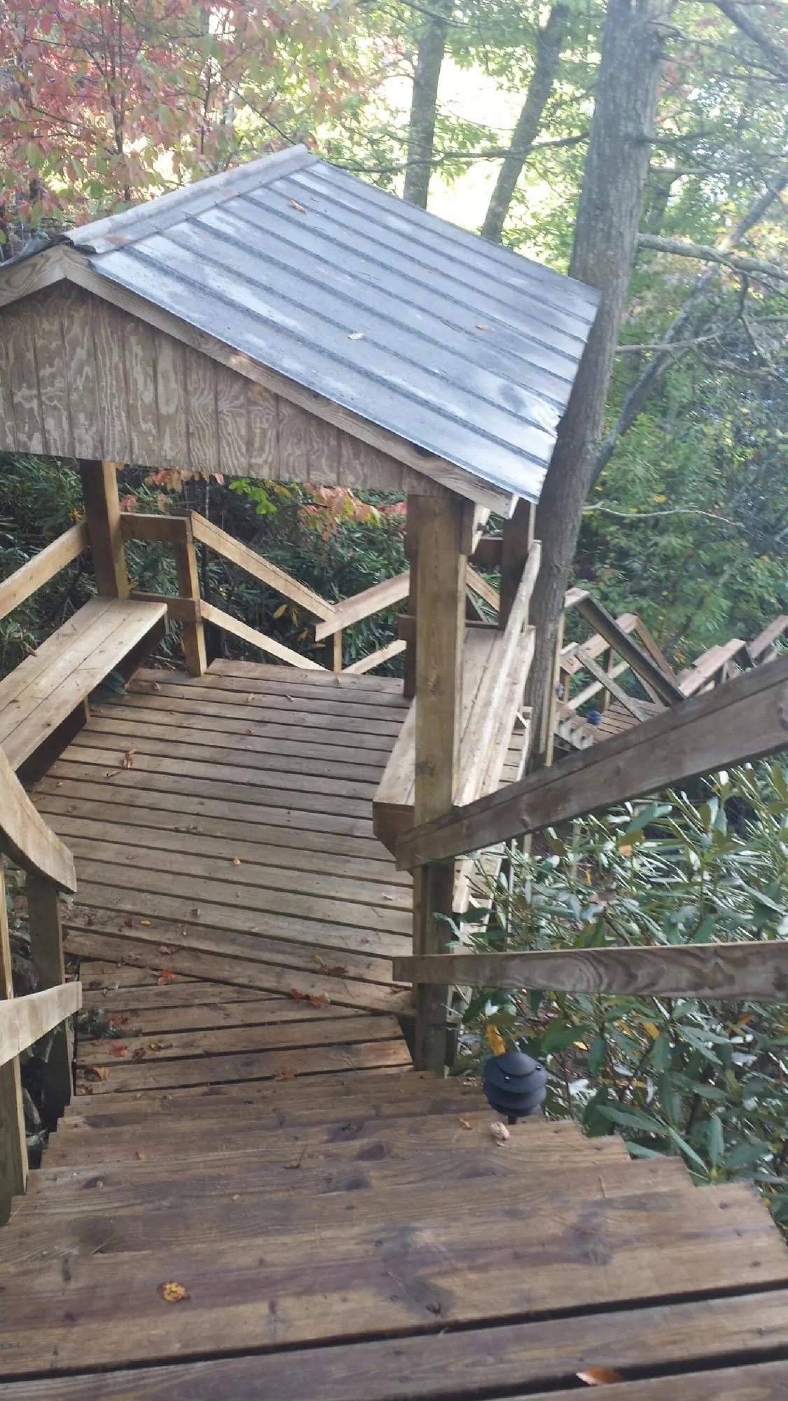 Metal roofed shelter over wooden steps on a wooded walkway — Skylight Repair & Installation work by our crew in Walkersville